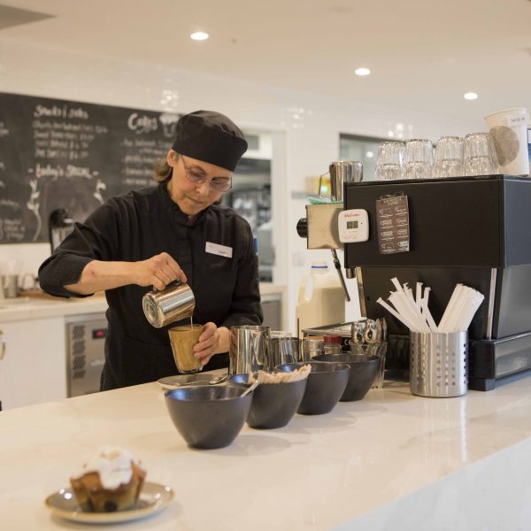 Barista serving coffee in the cafe at Mercy Place aged care Montrose